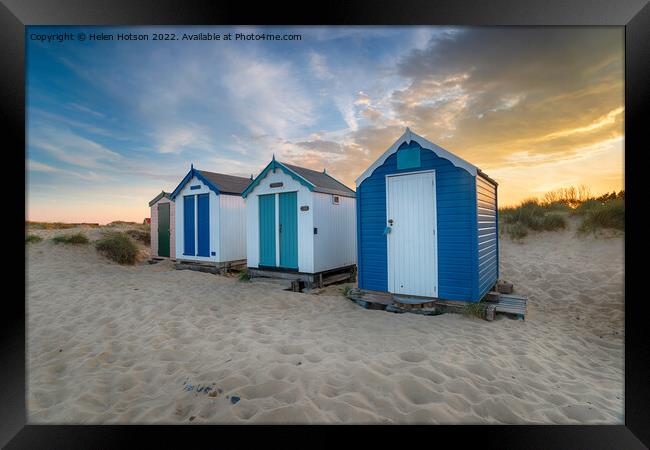 Sunset over a row of pretty beach huts at Southwold  Framed Print by Helen Hotson