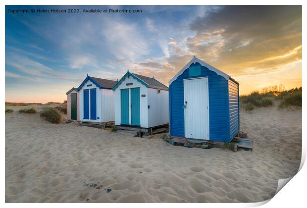 Sunset over a row of pretty beach huts at Southwold  Print by Helen Hotson