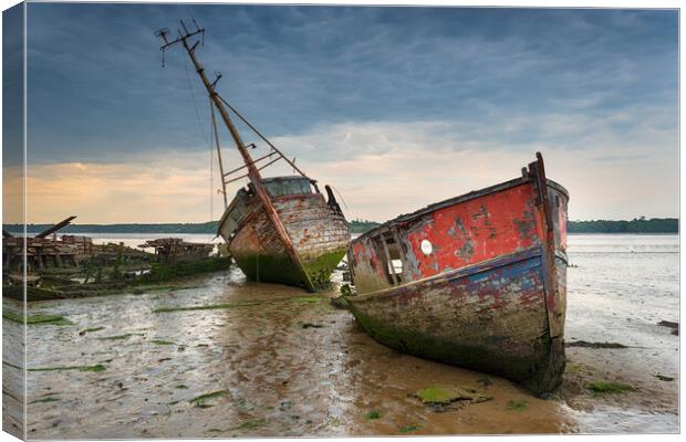 Old boat wrecks under a stormy sky Canvas Print by Helen Hotson