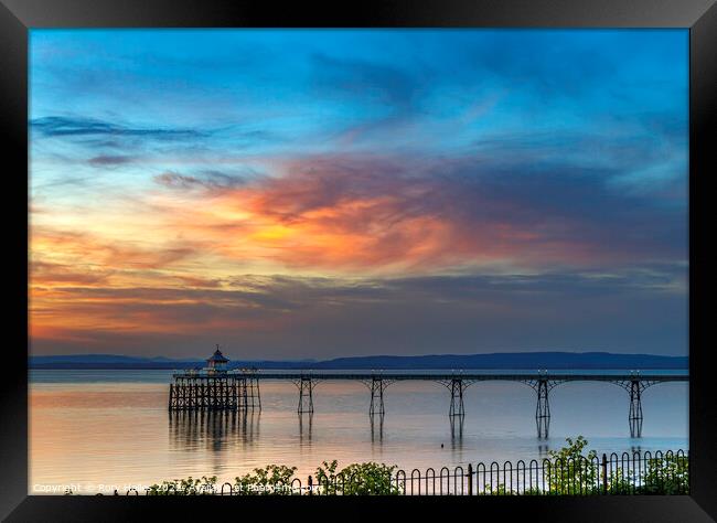 Clevedon Pier with the setting sun lighting up the cloud cover Framed Print by Rory Hailes