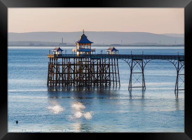 Clevedon Pier with sunlight reflecting onto the sea Framed Print by Rory Hailes