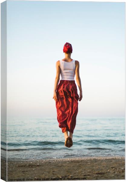 Woman jumping on the beach Canvas Print by Simo Wave