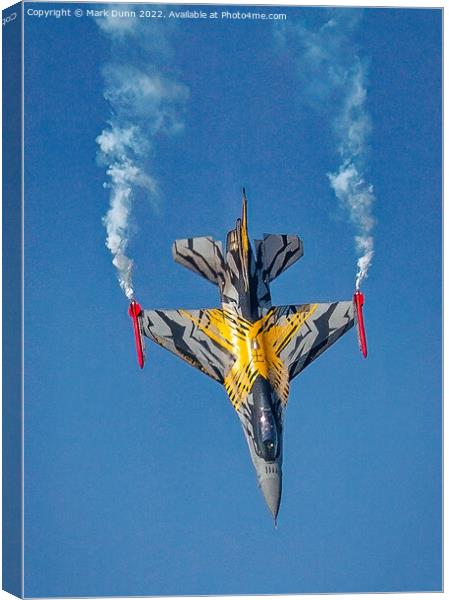 A F16 airplane that is flying in the air with smoke coming out of it Canvas Print by Mark Dunn