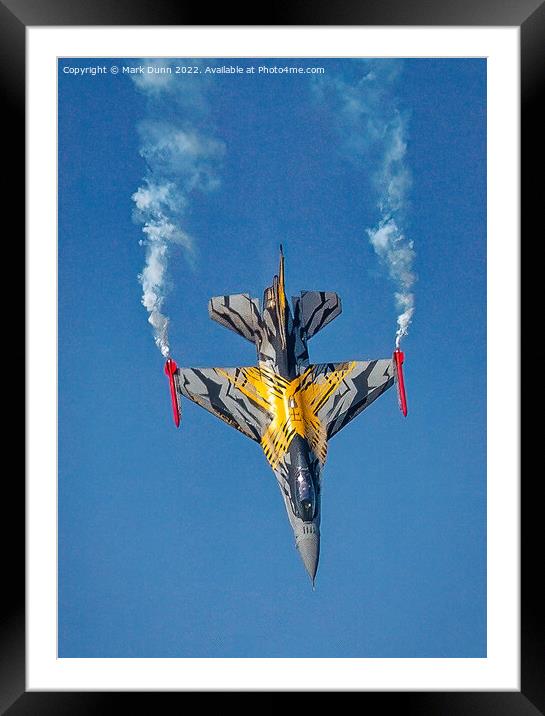 A F16 airplane that is flying in the air with smoke coming out of it Framed Mounted Print by Mark Dunn