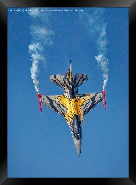 A F16 airplane that is flying in the air with smoke coming out of it Framed Print by Mark Dunn