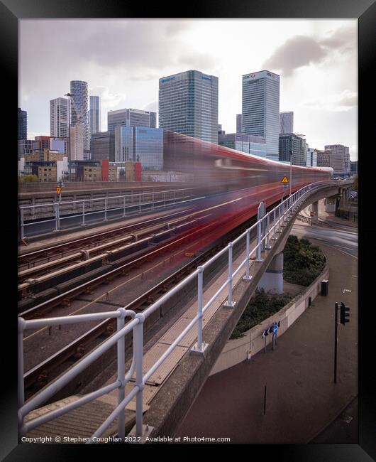 DLR arriving in front of Canary Wharf Framed Print by Stephen Coughlan