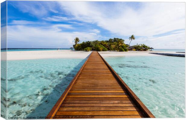 Wooden jetty to a tropical island, Maldives Canvas Print by Matteo Colombo
