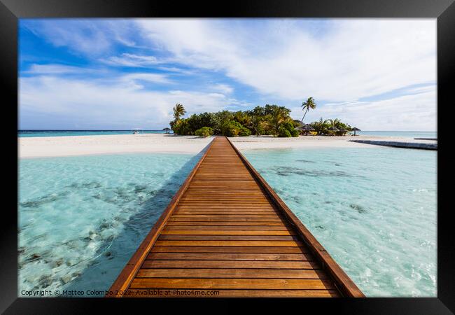 Wooden jetty to a tropical island, Maldives Framed Print by Matteo Colombo
