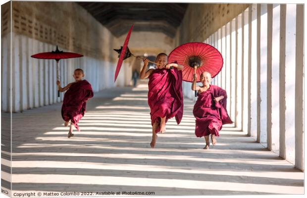 Novice monks with umbrellas running at temple, Bagan, Myanmar Canvas Print by Matteo Colombo