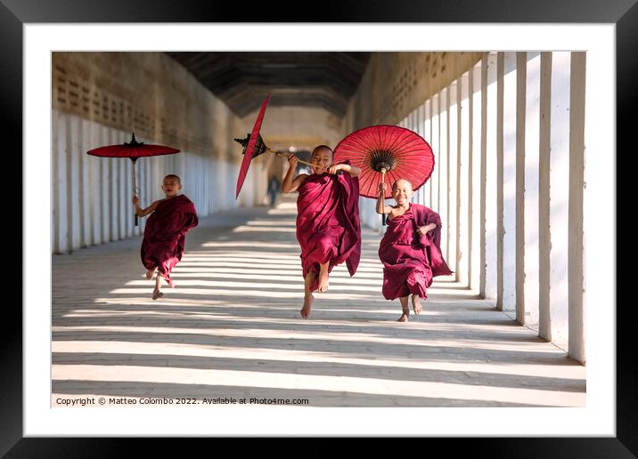 Novice monks with umbrellas running at temple, Bagan, Myanmar Framed Mounted Print by Matteo Colombo