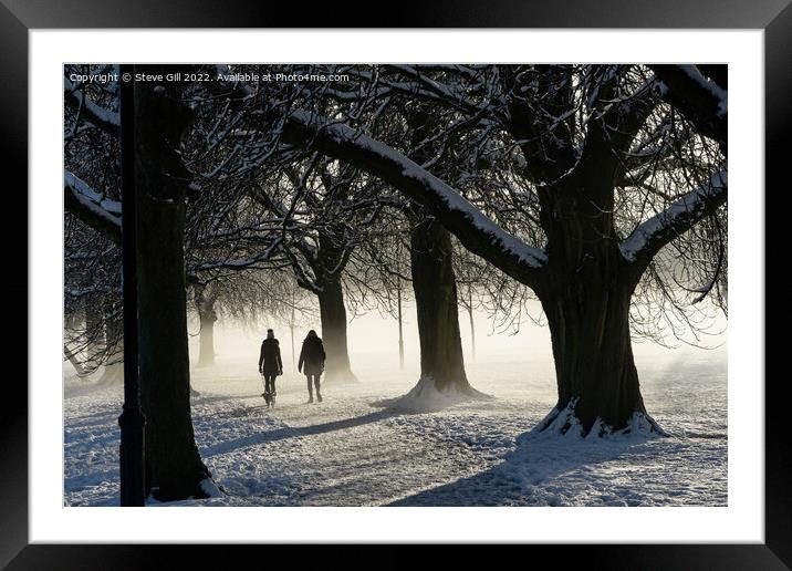 Two Women Walking a Dog on a Snowy Morning in the  Framed Mounted Print by Steve Gill