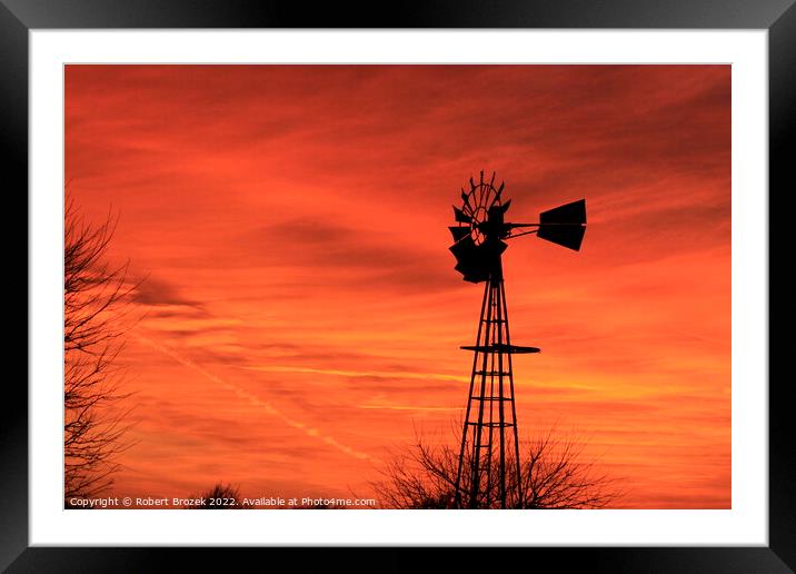 Kansas Sunset with red sky and a Windmill silhouet Framed Mounted Print by Robert Brozek