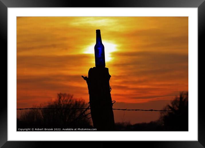 Sunset with a bottle on a fence post with sky. Framed Mounted Print by Robert Brozek