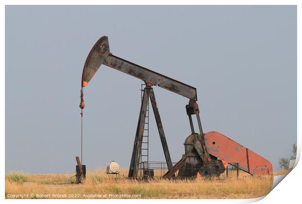 Oilwell Pump in a farm field with blue sky Print by Robert Brozek