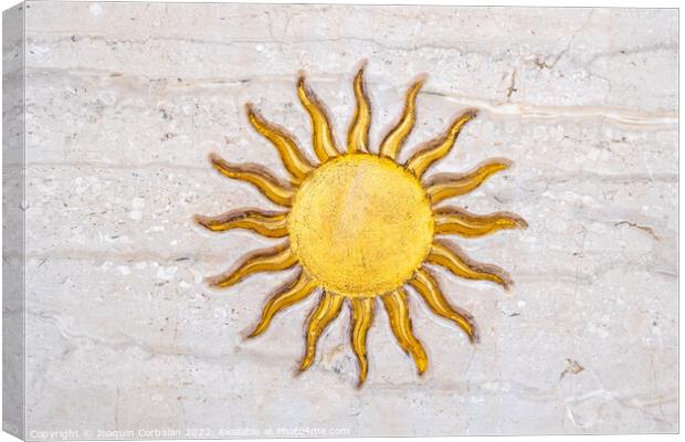 The drawing of a sun with golden rays engraved on marble on a wa Canvas Print by Joaquin Corbalan