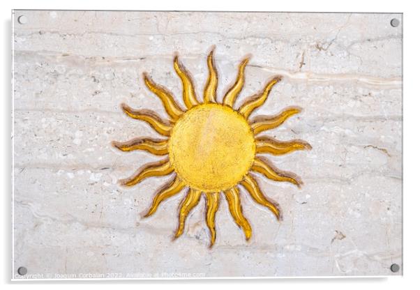The drawing of a sun with golden rays engraved on marble on a wa Acrylic by Joaquin Corbalan