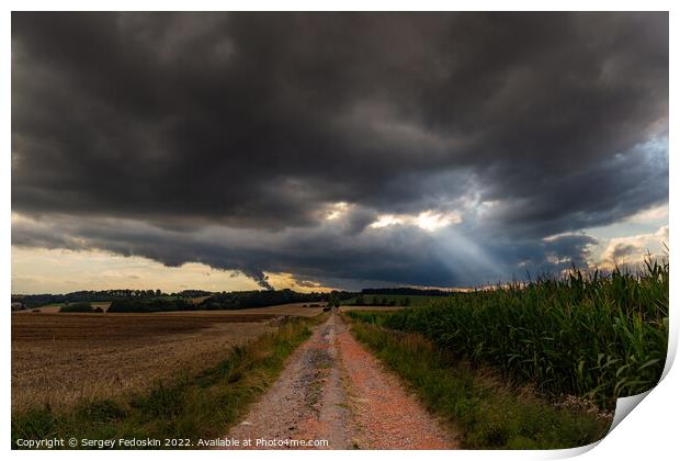 Dramatic storm clouds over fields. Country landscape. Windy weather. Plain field against the background of dark sky. Print by Sergey Fedoskin