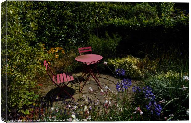 Floral Garden with a Rustic Iron Table and Chairs. Canvas Print by Steve Gill