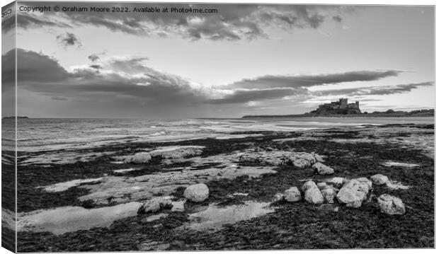 Bamburgh Castle from Harkness Rocks dusk monochrome Canvas Print by Graham Moore