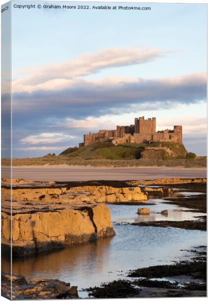 Bamburgh Castle from Harkness Rocks sunset vert Canvas Print by Graham Moore