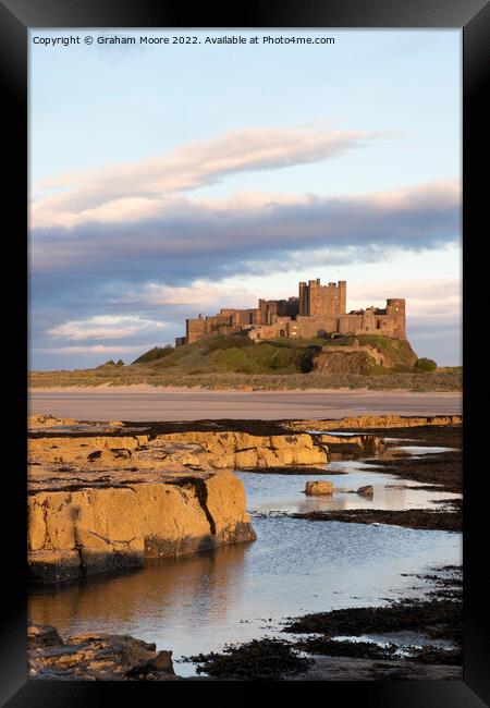 Bamburgh Castle from Harkness Rocks sunset vert Framed Print by Graham Moore