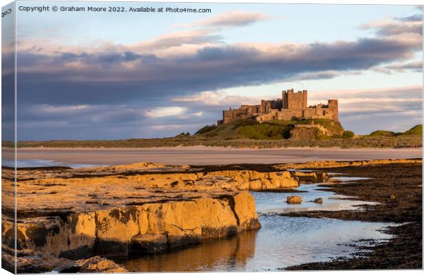 Bamburgh Castle from Harkness Rocks sunset Canvas Print by Graham Moore