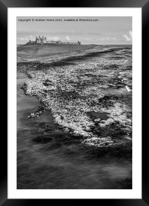 Dunstanburgh Castle from the sea elevated monochrome Framed Mounted Print by Graham Moore