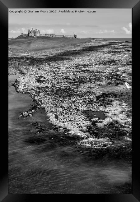 Dunstanburgh Castle from the sea elevated monochrome Framed Print by Graham Moore