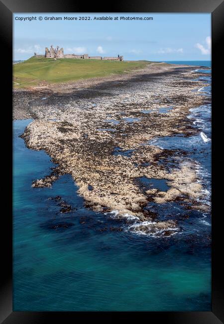 Dunstanburgh Castle from the sea elevated Framed Print by Graham Moore