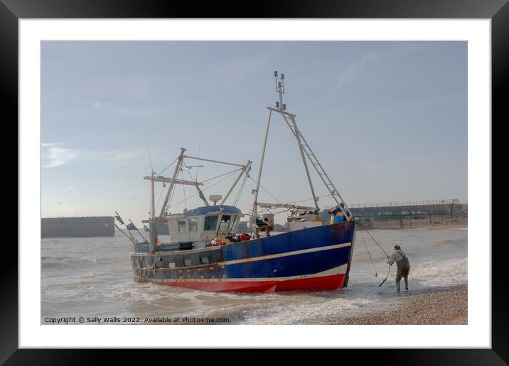 Fishing boat being landed on beach Framed Mounted Print by Sally Wallis