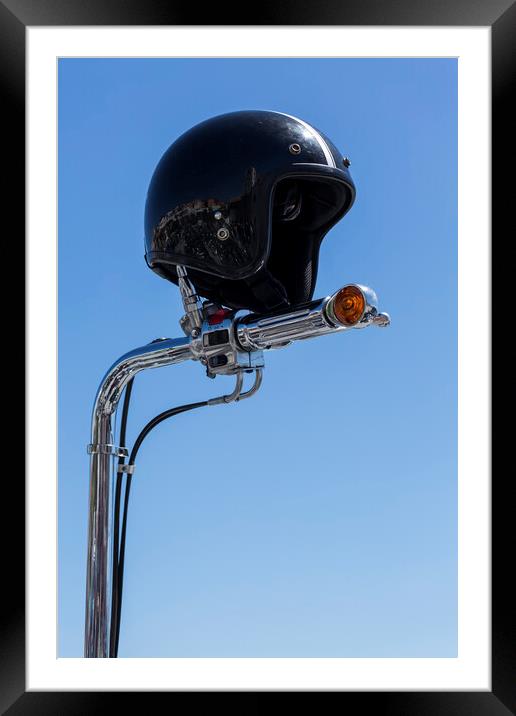 Open face crash helmet on handlebars of a motorcycle against a blue sky Framed Mounted Print by Phil Crean