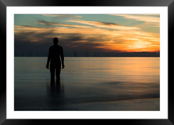 Iron man at sunset Framed Mounted Print by Clive Wells