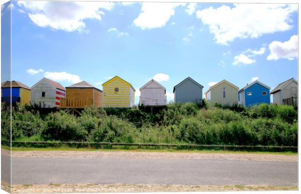 Silhouetted beach huts at Chapel point. Canvas Print by john hill