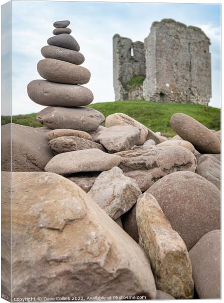 A small rocky cairn on the rocky sea wall at Minard Beach with the remains of Minard Castle defocused in the back, County Kerry, Ireland Canvas Print by Dave Collins