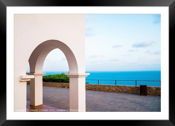 The sea can be seen from the top of a hill, through the traditio Framed Mounted Print by Joaquin Corbalan
