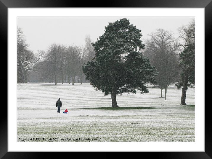 Man with child on sledge Framed Mounted Print by Rick Parrott