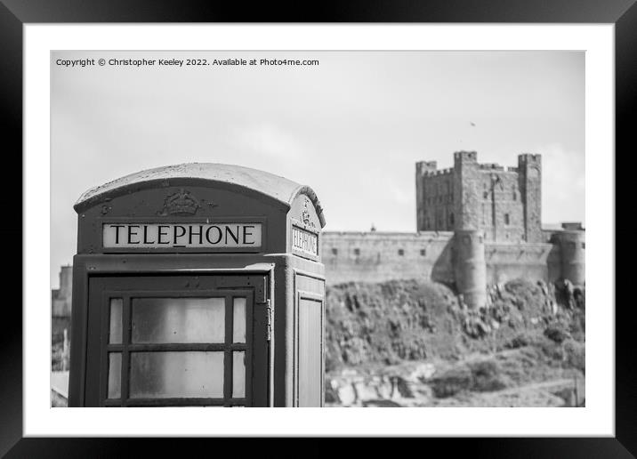 Black and white Bamburgh Castle telephone box Framed Mounted Print by Christopher Keeley