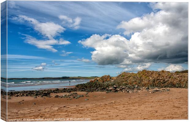 Volcanic rock, blue sky and clouds on Newborough beach, Anglesey Canvas Print by Kevin Hellon