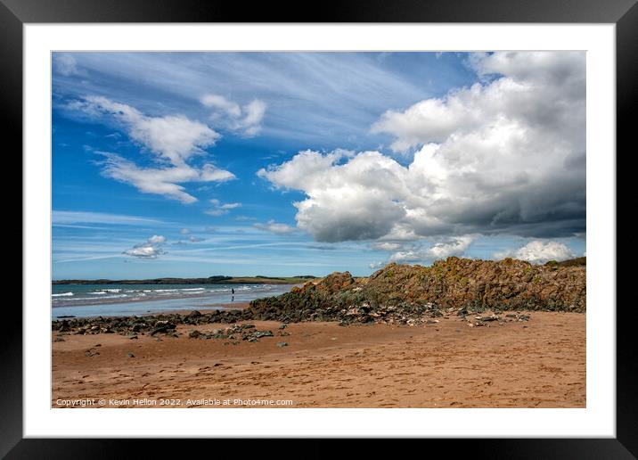 Volcanic rock, blue sky and clouds on Newborough beach, Anglesey Framed Mounted Print by Kevin Hellon