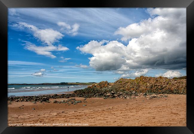 Volcanic rock, blue sky and clouds on Newborough beach, Anglesey Framed Print by Kevin Hellon