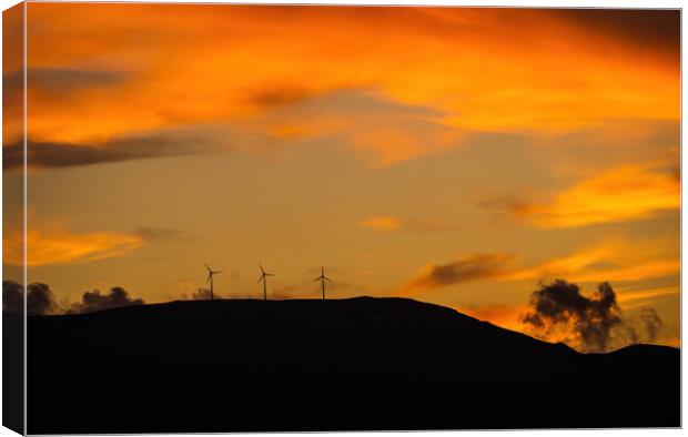 Clean energy power concept with wind turbine on top of a mountain during dramatic sunset Canvas Print by Arpan Bhatia