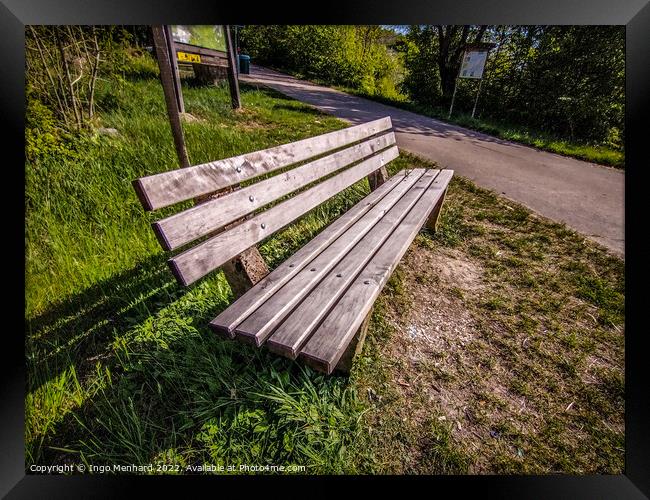 High angle shot of a bench near a street Framed Print by Ingo Menhard