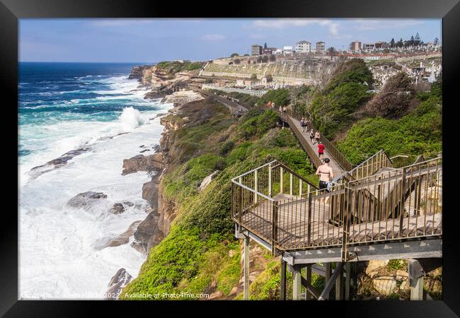 The Bondi to Coogee coastal walk with rough seas and Waverley ce Framed Print by Kevin Hellon