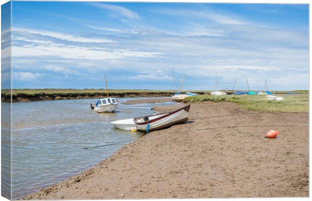 Boats along a channel at Blakeney Canvas Print by Jason Wells