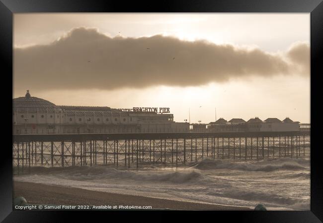 Brighton Pier on a stormy windy day with sun coming through clouds Framed Print by Samuel Foster