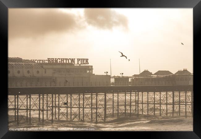 Brighton Pier on a stormy windy day with sun coming through clouds Framed Print by Samuel Foster