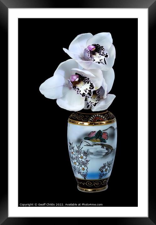  White Cymbidium Orchids in a vase on black. Framed Mounted Print by Geoff Childs