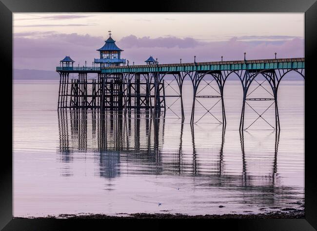 Clevedon Pier with its leg reflecting onto a calm sea Framed Print by Rory Hailes