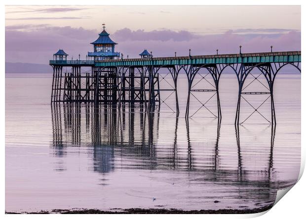 Clevedon Pier with its leg reflecting onto a calm sea Print by Rory Hailes