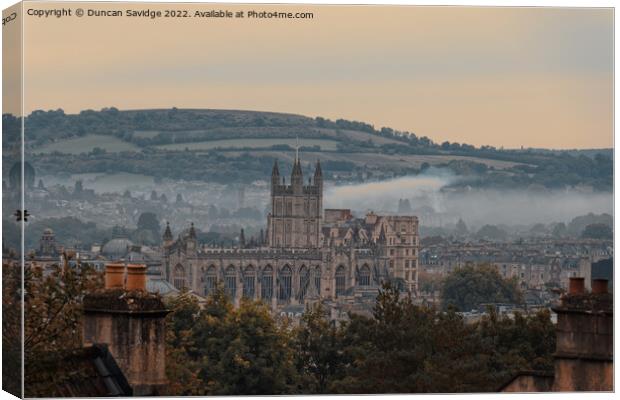 Moody early morning mist rising behind Bath Abbey Canvas Print by Duncan Savidge